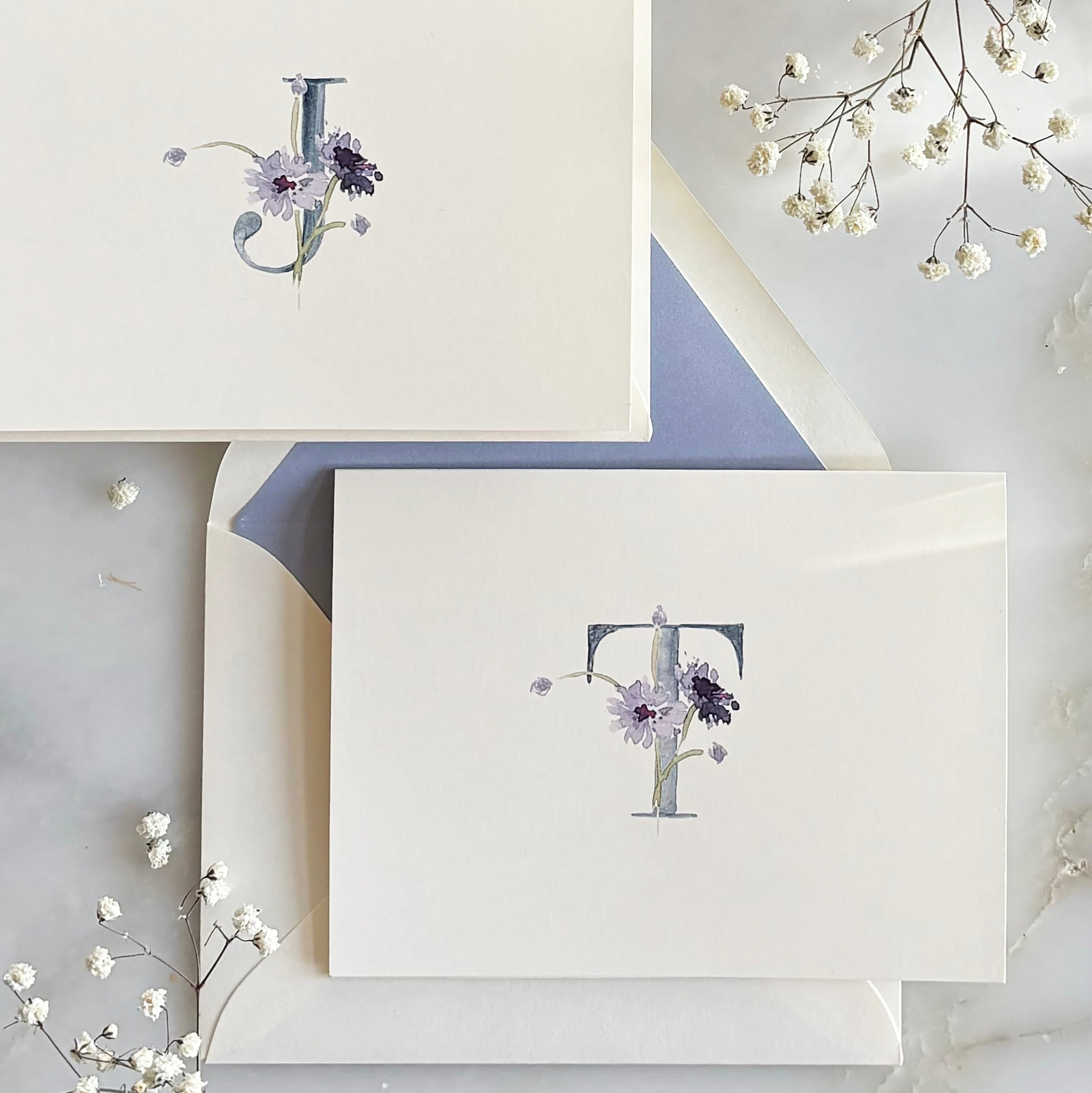 Stationery set with a card and envelope featuring a decorative design on a marble surface.